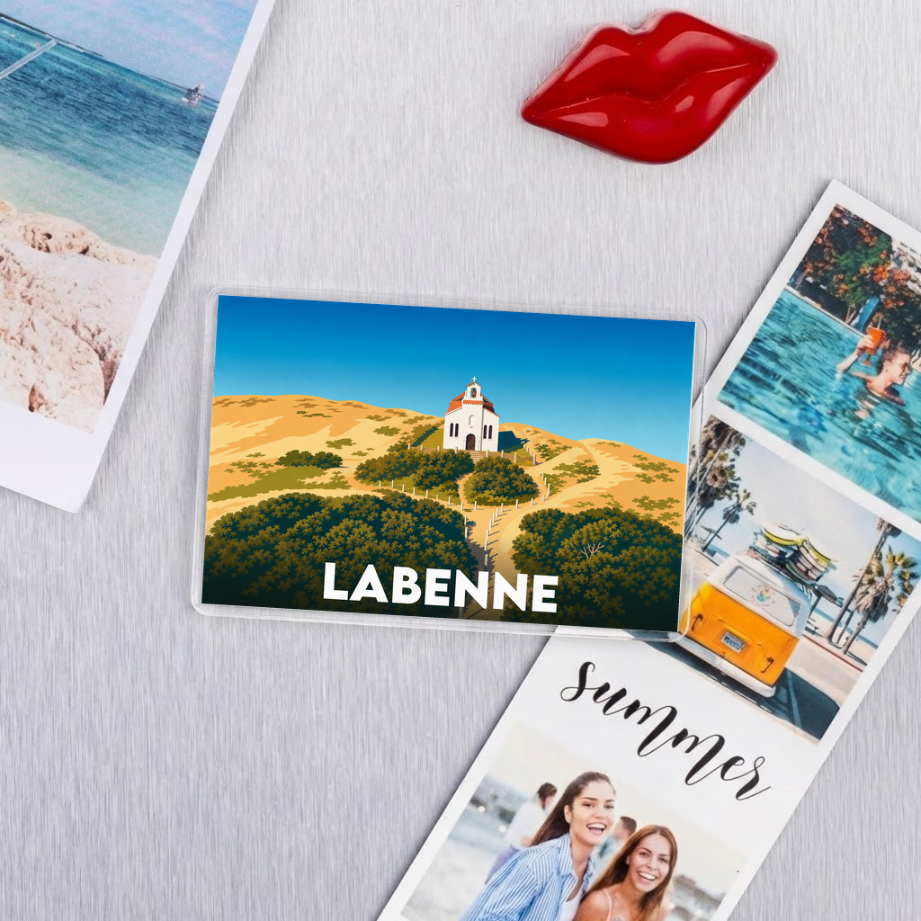 Magnet souvenir de la ville de Labenne avec une illustration stylisée d'une église sur une dune de sable.