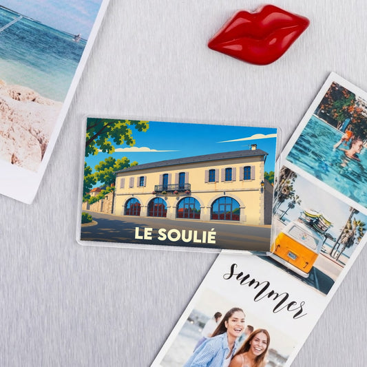Magnet souvenir de la ville de Le Soulié avec une illustration stylisée d'un bâtiment typique.
