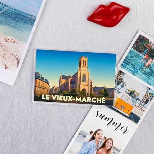 Magnet souvenir de la ville de Le Vieux-Marché avec une illustration stylisée d'une église sous un ciel azur.