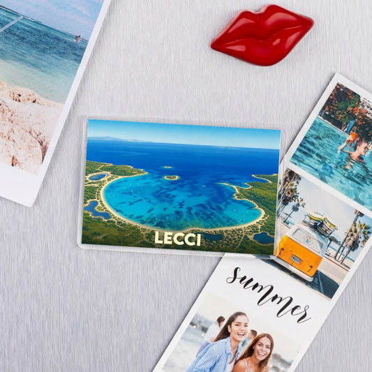 Magnet souvenir de la ville de Lecci représentant une vue aérienne d'une baie aux eaux turquoise.