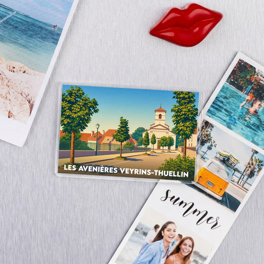 Magnet souvenir de la ville de Les Avenières Veyrins-Thuellin avec une illustration stylisée d'une place ensoleillée.