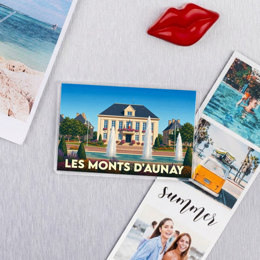 Magnet souvenir de la ville de Les Monts d'Aunay avec une illustration stylisée de son hôtel de ville et de ses fontaines.