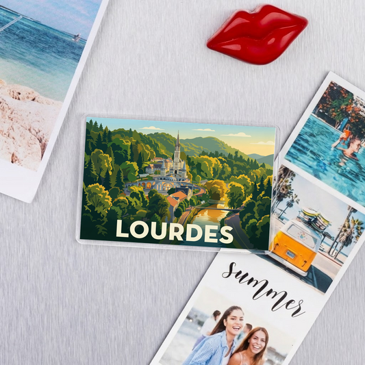 Magnet souvenir de la ville de Lourdes avec une illustration stylisée de son paysage.