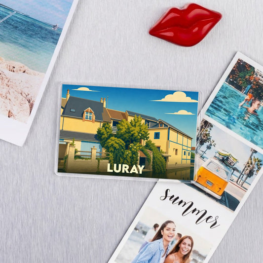 Magnet souvenir de la ville de Luray avec une illustration stylisée d'une maison jaune sous un ciel bleu.