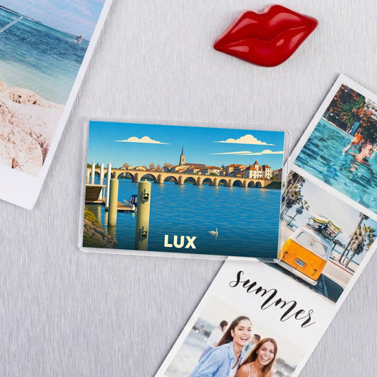 Magnet souvenir de la ville de Lux avec une illustration stylisée d'un pont et de son église.