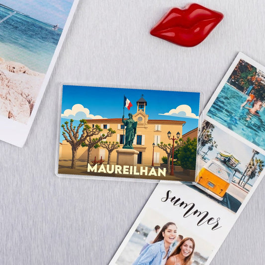 Magnet souvenir de la ville de Maureilhan avec une illustration stylisée de sa place principale.