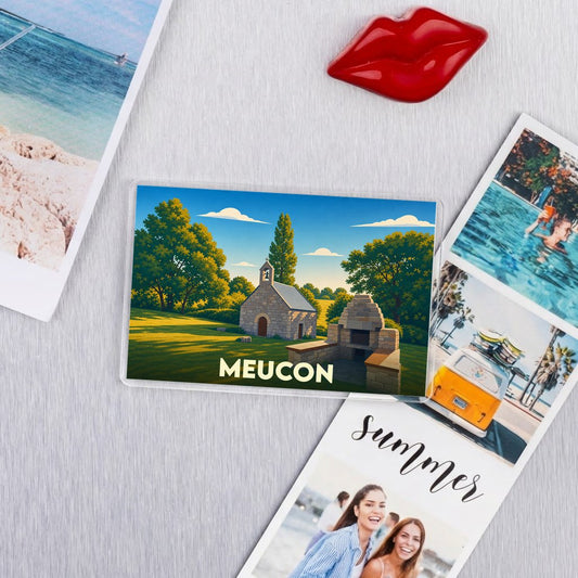 Magnet souvenir de la ville de Meucon avec une illustration stylisée d'une petite chapelle en pierre.