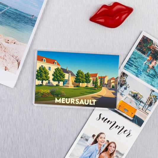 Magnet souvenir de la ville de Meursault illustrant une place ensoleillée dans un style graphique épuré.