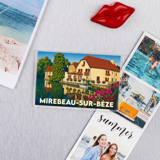 Magnet souvenir de la ville de Mirebeau-sur-Bèze avec une illustration stylisée d'une maison au bord de l'eau.