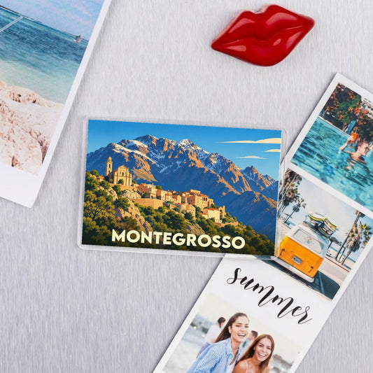 Magnet souvenir de la ville de Montegrosso avec une illustration stylisée de ses montagnes et de son église.