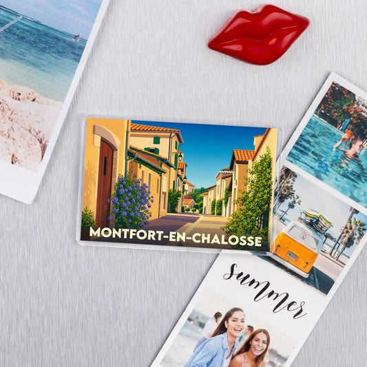 Magnet souvenir de la ville de Montfort-en-Chalosse avec une illustration stylisée d'une rue ensoleillée.
