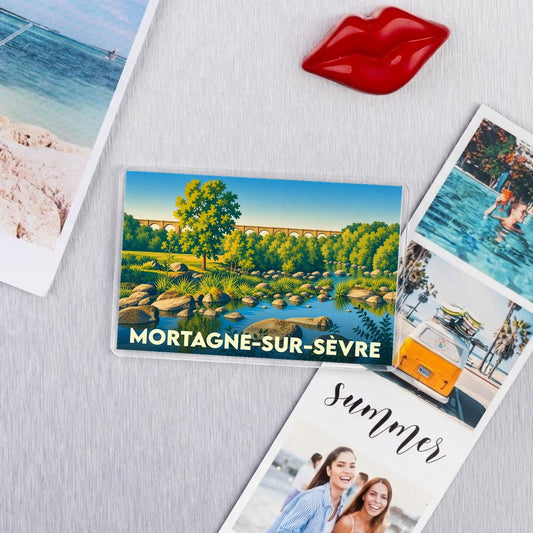 Magnet souvenir de la ville de Mortagne-sur-Sèvre avec une illustration stylisée de son paysage fluvial.