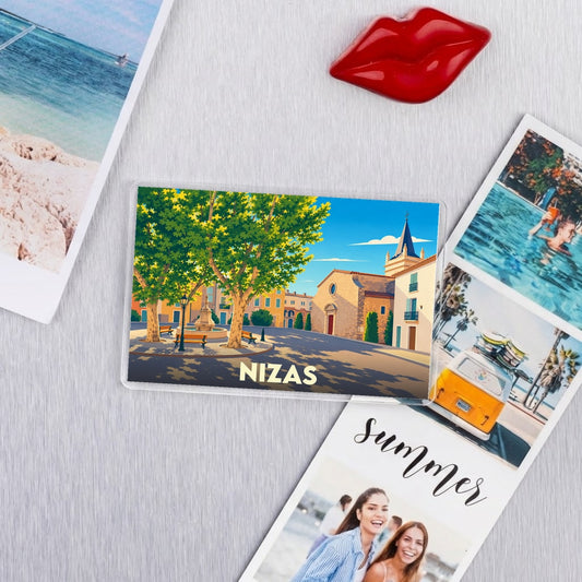 Magnet souvenir de la ville de Nizas avec une illustration stylisée de sa place principale.