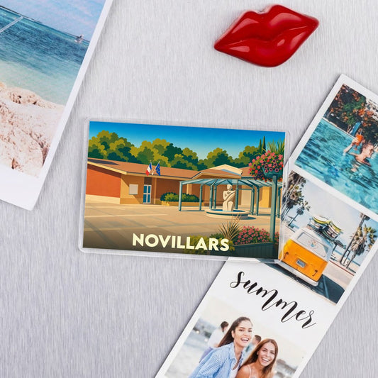 Magnet souvenir de la ville de Novillars avec une illustration stylisée et colorée.