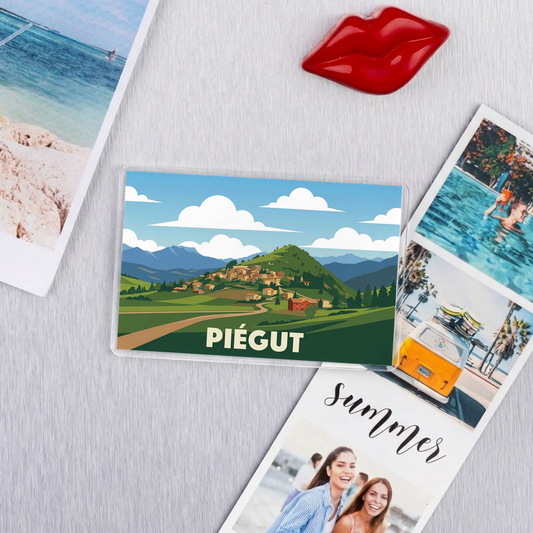 Magnet souvenir de la ville de Piégut avec une illustration stylisée de son paysage.