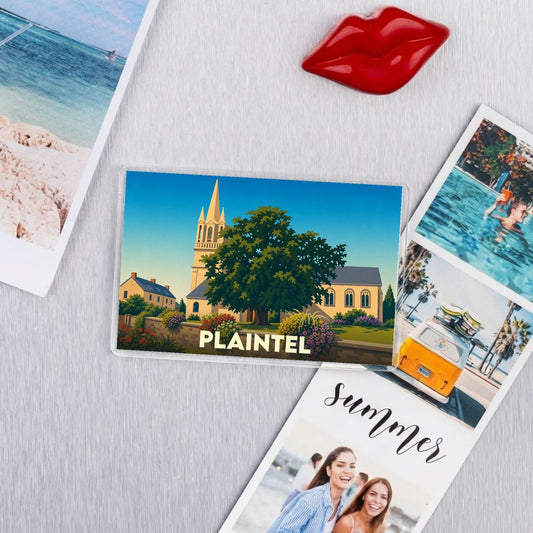 Magnet souvenir de la ville de Plaintel avec une illustration stylisée d'une église et d'un grand arbre.