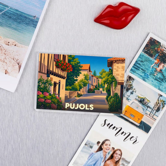 Magnet souvenir de la ville de Pujols avec une illustration stylisée d'une ruelle fleurie.