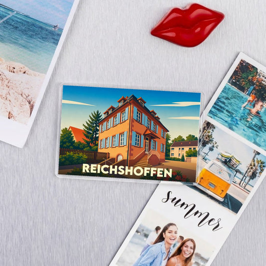 Magnet souvenir de la ville de Reichshoffen avec une illustration stylisée d'une maison traditionnelle alsacienne.