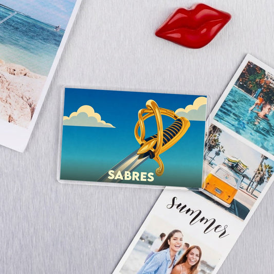 Magnet souvenir de la ville de Sabres avec une illustration stylisée d'un sabre.
