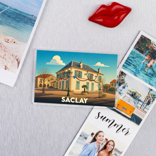 Magnet souvenir de la ville de Saclay avec une illustration stylisée d'un bâtiment emblématique sous un ciel azur.