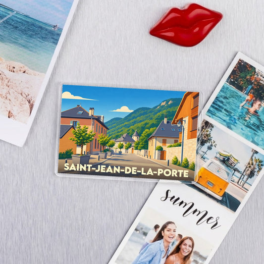 Magnet souvenir de la ville de Saint-Jean-de-la-Porte avec une illustration de ses rues pittoresques et des montagnes.