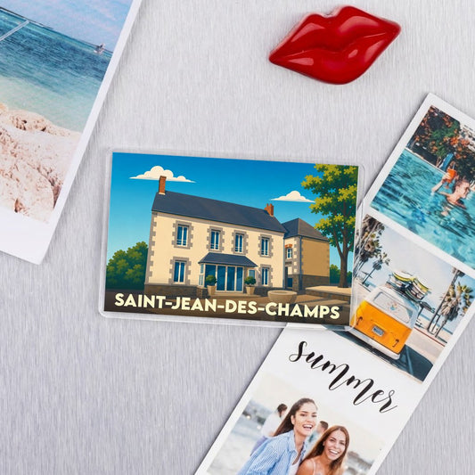 Magnet souvenir de Saint-Jean-des-Champs arborant une illustration stylisée d'une maison de campagne.