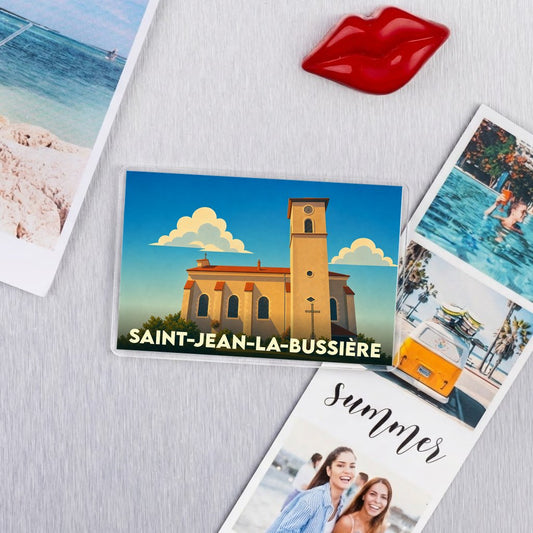 Magnet souvenir de Saint-Jean-la-Bussière avec une illustration stylisée de son église.