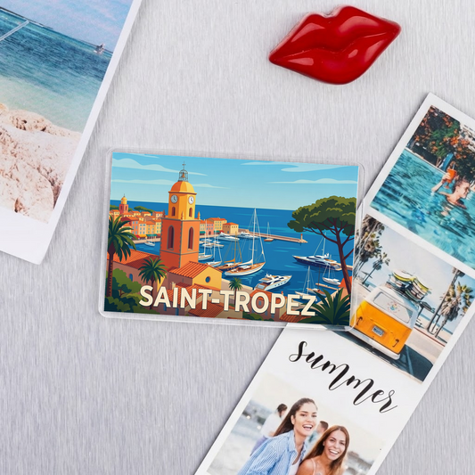 Magnet souvenir de la ville de Saint-Tropez avec une illustration stylisée de son clocher emblématique et de son port.