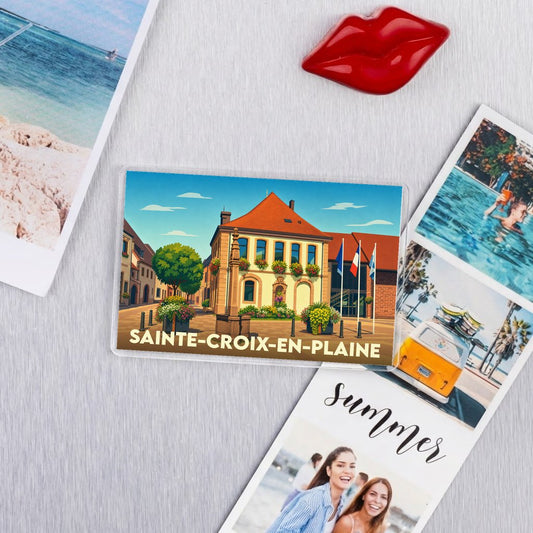 Magnet souvenir de la ville de Sainte-Croix-en-Plaine avec une illustration colorée et stylisée de sa mairie.