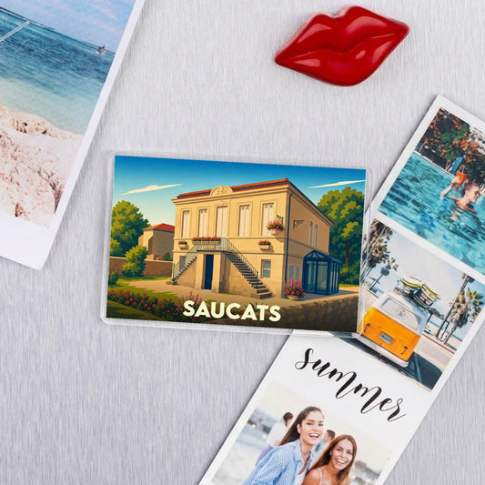Magnet souvenir de la ville de Saucats avec une illustration stylisée de son architecture.