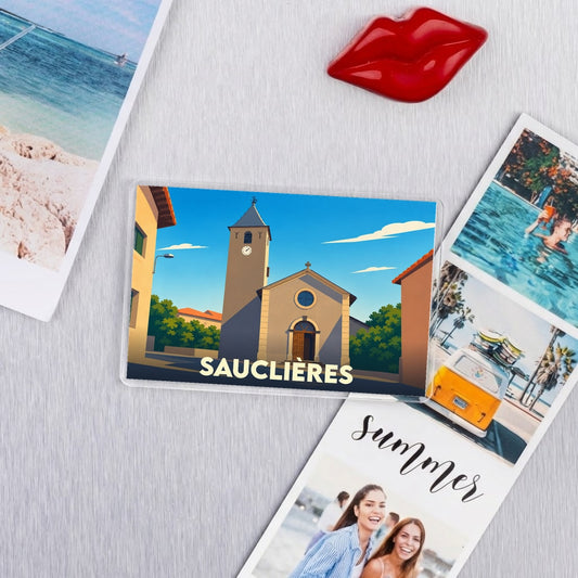 Magnet souvenir de la ville de Sauclières avec une illustration stylisée d'une église.