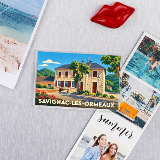 Magnet souvenir de la ville de Savignac-les-Ormeaux avec une illustration stylisée d'un bâtiment en pierre.