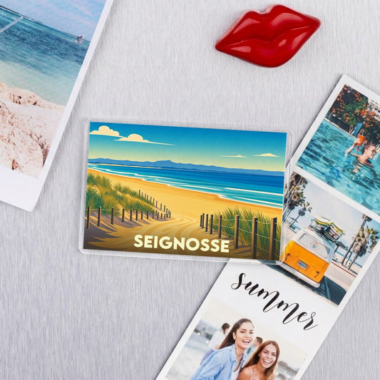 Magnet souvenir de la ville de Seignosse avec une illustration stylisée de plage et de dunes.