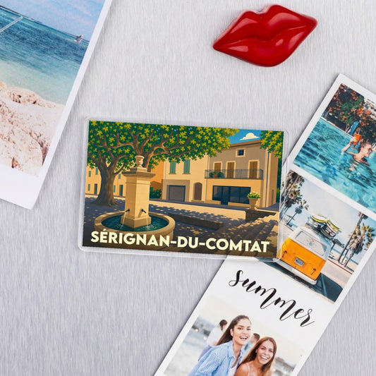 Magnet souvenir de la ville de Sérignan-du-Comtat avec une illustration stylisée d'une place provençale.