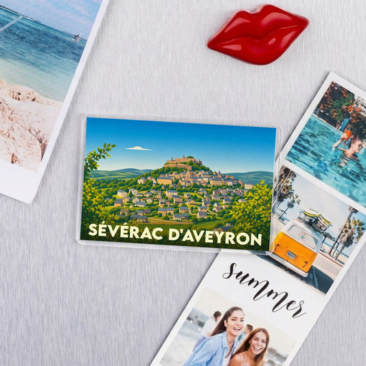 Magnet souvenir de la ville de Sévérac d'Aveyron avec une illustration stylisée d'un village médiéval perché.