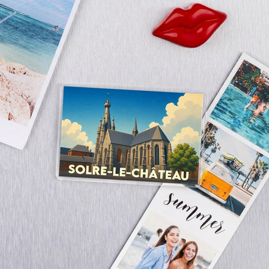 Magnet souvenir de la ville de Solre-le-Château avec une illustration stylisée de son église penchée.