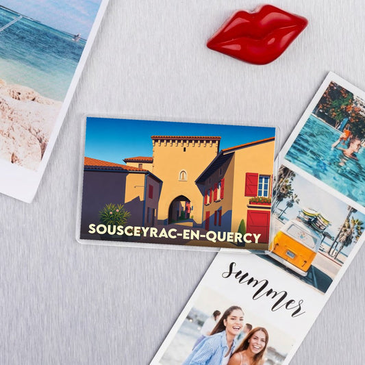 Magnet souvenir de la ville de Sousceyrac-en-Quercy avec une illustration stylisée de son architecture.