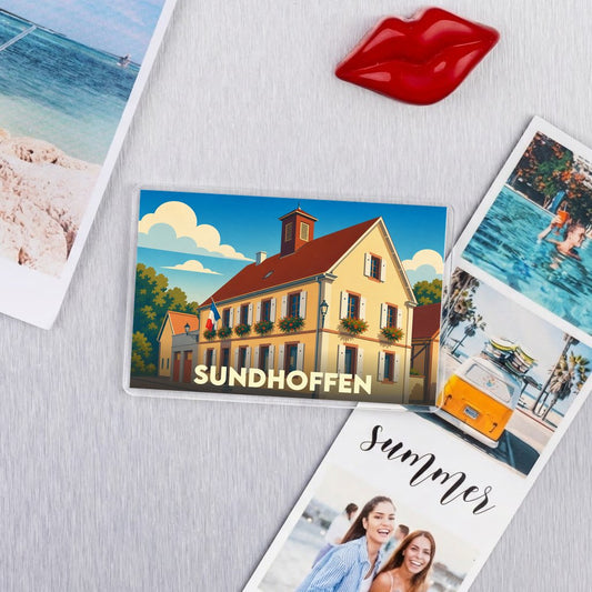 Magnet souvenir de la ville de Sundhoffen avec une illustration stylisée d'un bâtiment typique.