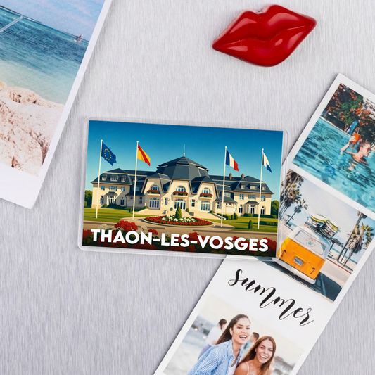 Magnet souvenir de la ville de Thaon-les-Vosges avec une illustration stylisée de son patrimoine architectural.