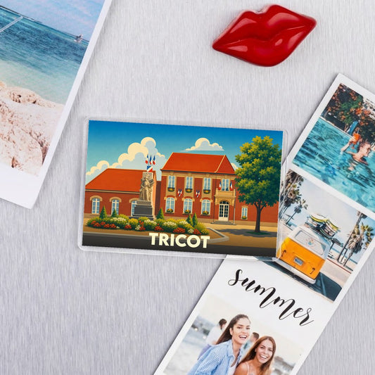 Magnet souvenir de la ville de Tricot avec une illustration stylisée de sa mairie et de son monument.