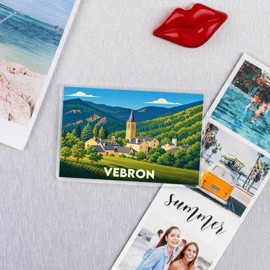 Magnet souvenir de la ville de Vebron avec une illustration stylisée d'un village de montagne.