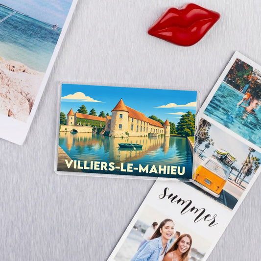 Magnet souvenir de la ville de Villiers-le-Mahieu avec une illustration stylisée de son château bordé d'eau.