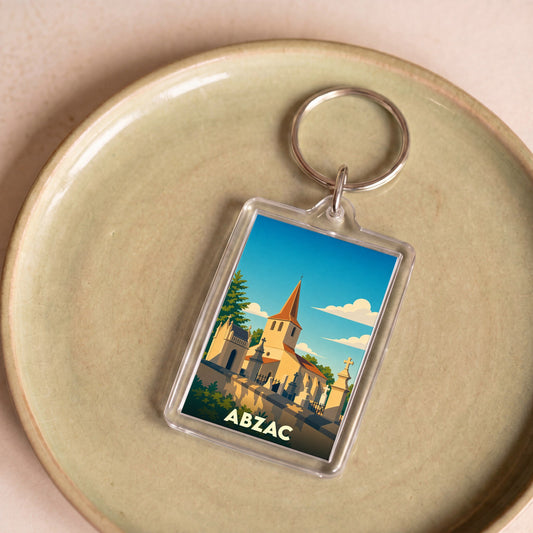 Porte-clés souvenir de la ville d'Abzac avec une illustration stylisée de son église.