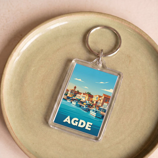Porte-clés souvenir de la ville d'Agde avec une illustration stylisée du port.
