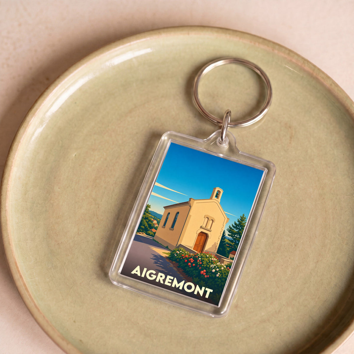 Porte-clés souvenir de la ville d'Aigremont avec une illustration stylisée de sa chapelle.