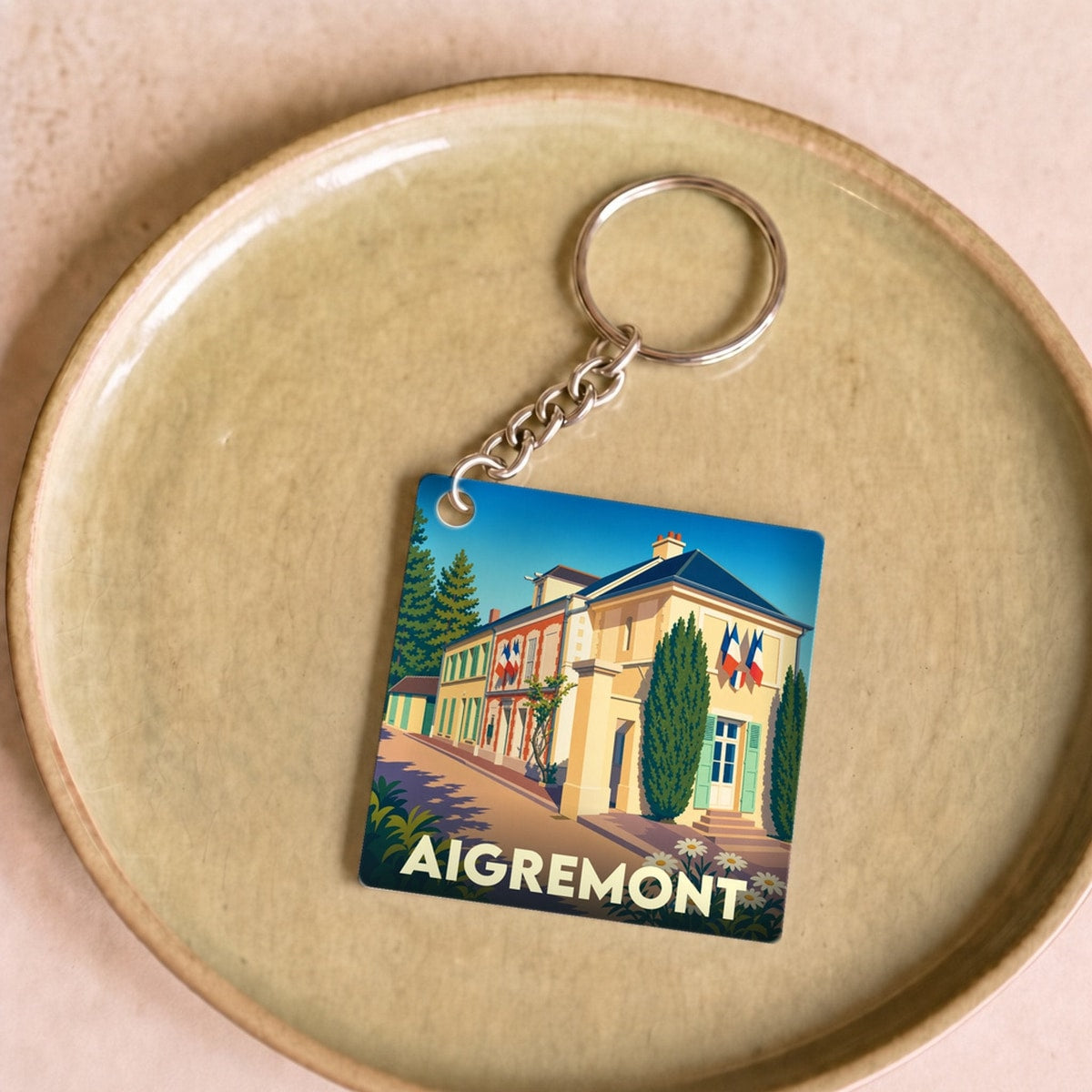 Porte-clés souvenir de la ville d’Aigremont avec une illustration stylisée.