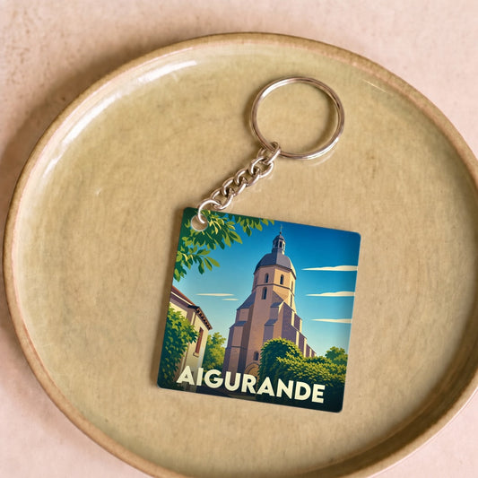 Porte-clés souvenir de la ville d'Aigurande avec une illustration stylisée de son église.