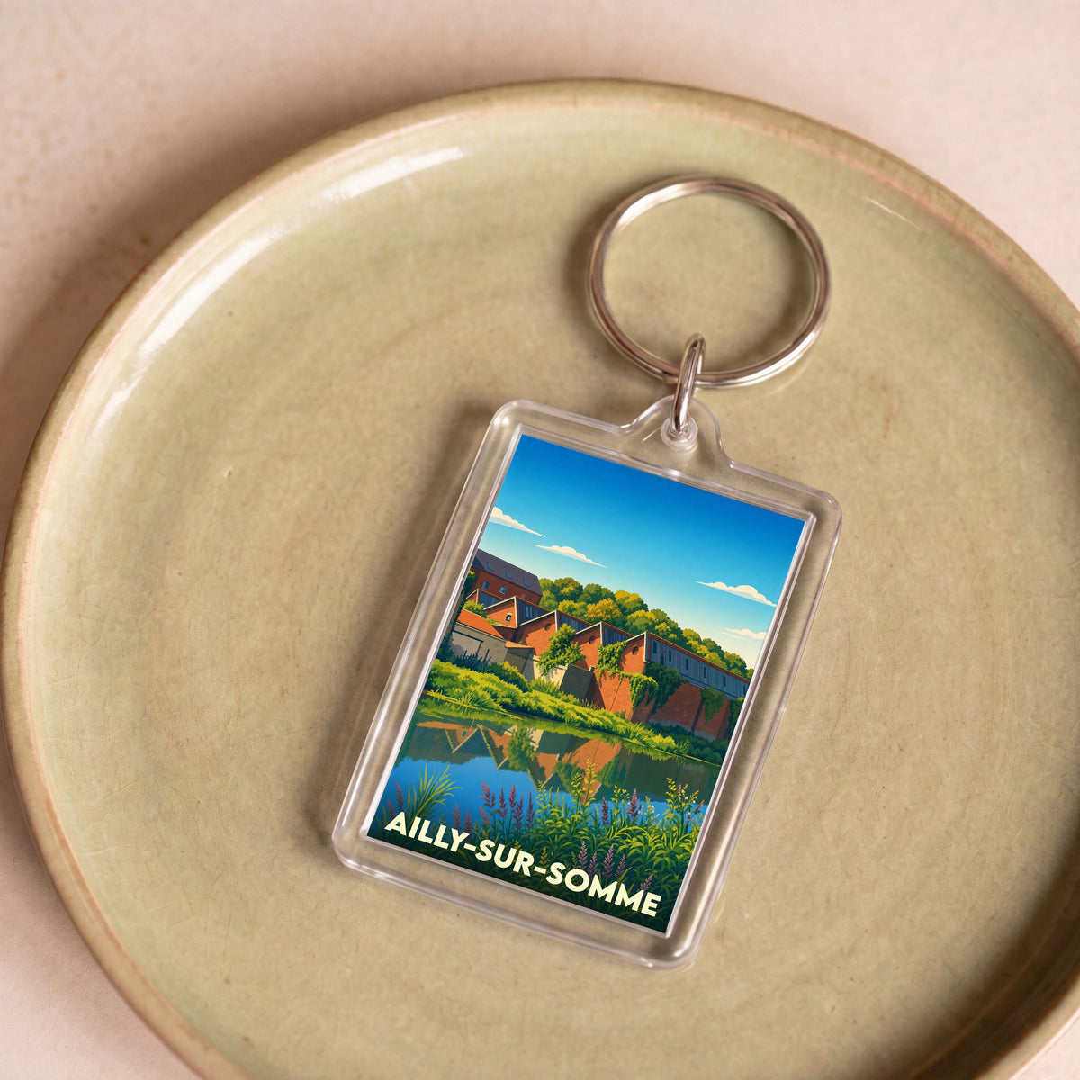 Porte-clés souvenir de la ville d'Ailly-sur-Somme avec une illustration stylisée.