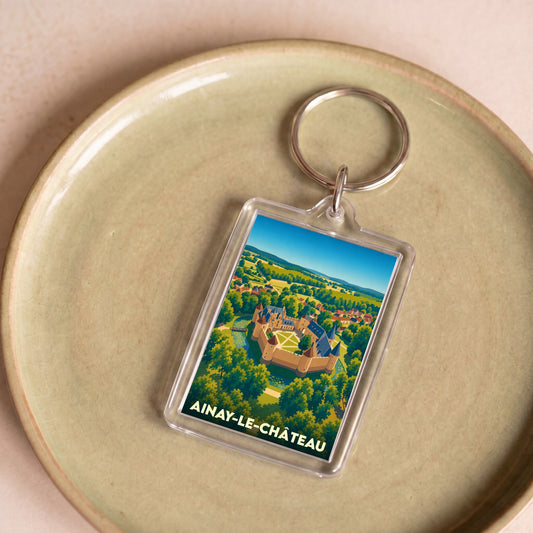 Porte-clés souvenir de la ville de Ainay-le-Château avec une illustration stylisée de son château.