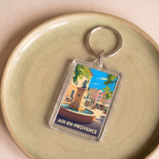 Porte-clés souvenir de la ville d'Aix-en-Provence avec une illustration stylisée d'une place ensoleillée.